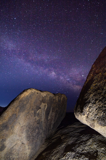 Boulders balanced against each other and the night sky