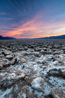 A colorful sunset contrasting a harsh landscape